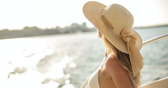 Luxurious Voyage - Back view of slim female in bikini top and straw hat enjoying trip on cruise boat on sunny day while relaxing during summer vacation and looking away