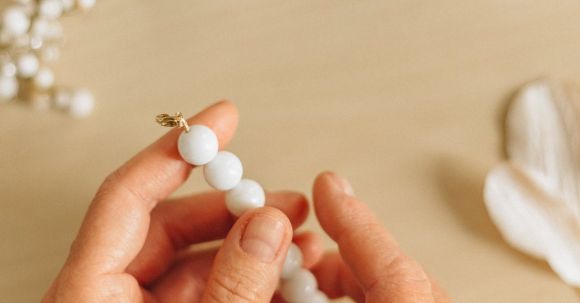 Handmade Elegance - Person Holding White Pearl Beads