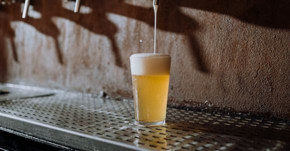 Craft Beer Guide - Beer Pouring Into Clear Drinking Glass on Metal Surface