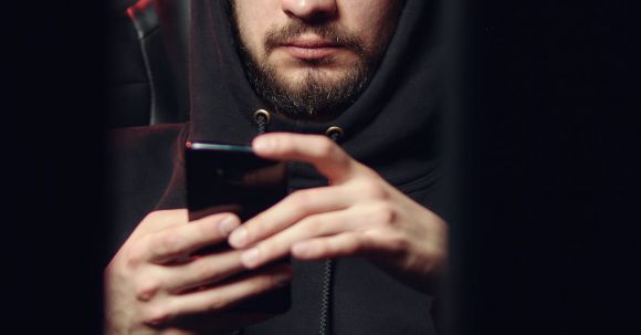Secure Browsing - Man in a Black Hoodie Browsing His Smartphone