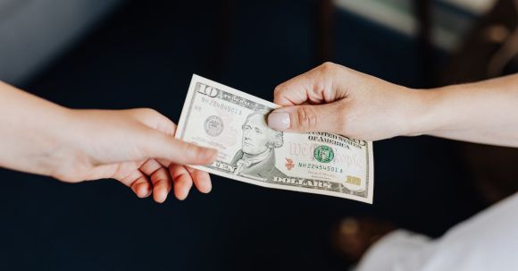 Profit Maximization: Tips - Hands Holding a 10 Dollar Bill