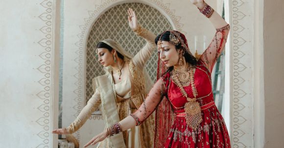 Traditional Dance - Woman in Red Dress Standing Beside Woman in White Dress