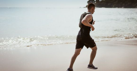 Fun Workout - Man Wearing Black Tank Top and Running on Seashore