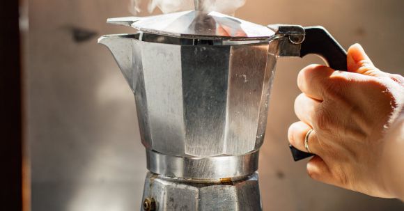 Perfect Brewing - A Person Brewing Coffee with a Stainless Stove Top Espresso Maker