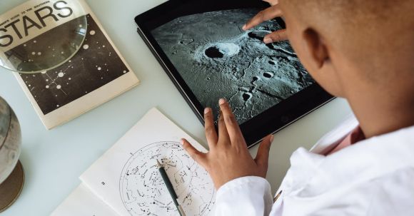 Technology, Healthcare - Crop African American student studying craters of moon on tablet at observatory