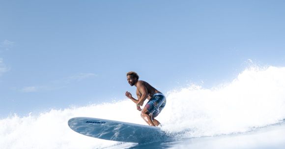 Fun, Active Sport. - Man surfing on blue sea water