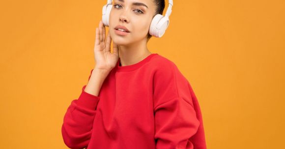 Hottest Trends. - Woman in Red Sweatshirt and Blue Jeans Wearing White Headphones